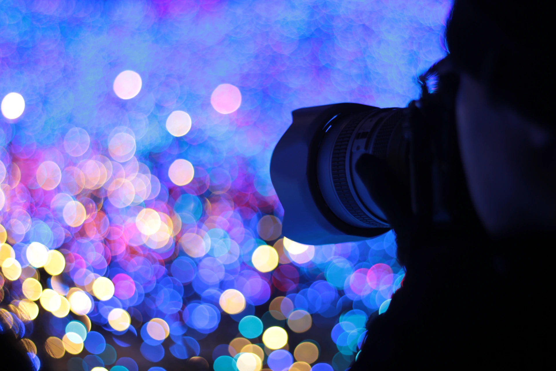 cropped-image-person-photographing-defocused-illuminated-city
